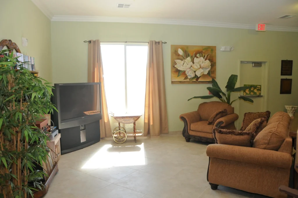 A living room with couches and a TV that provides cognitive stimulation.
